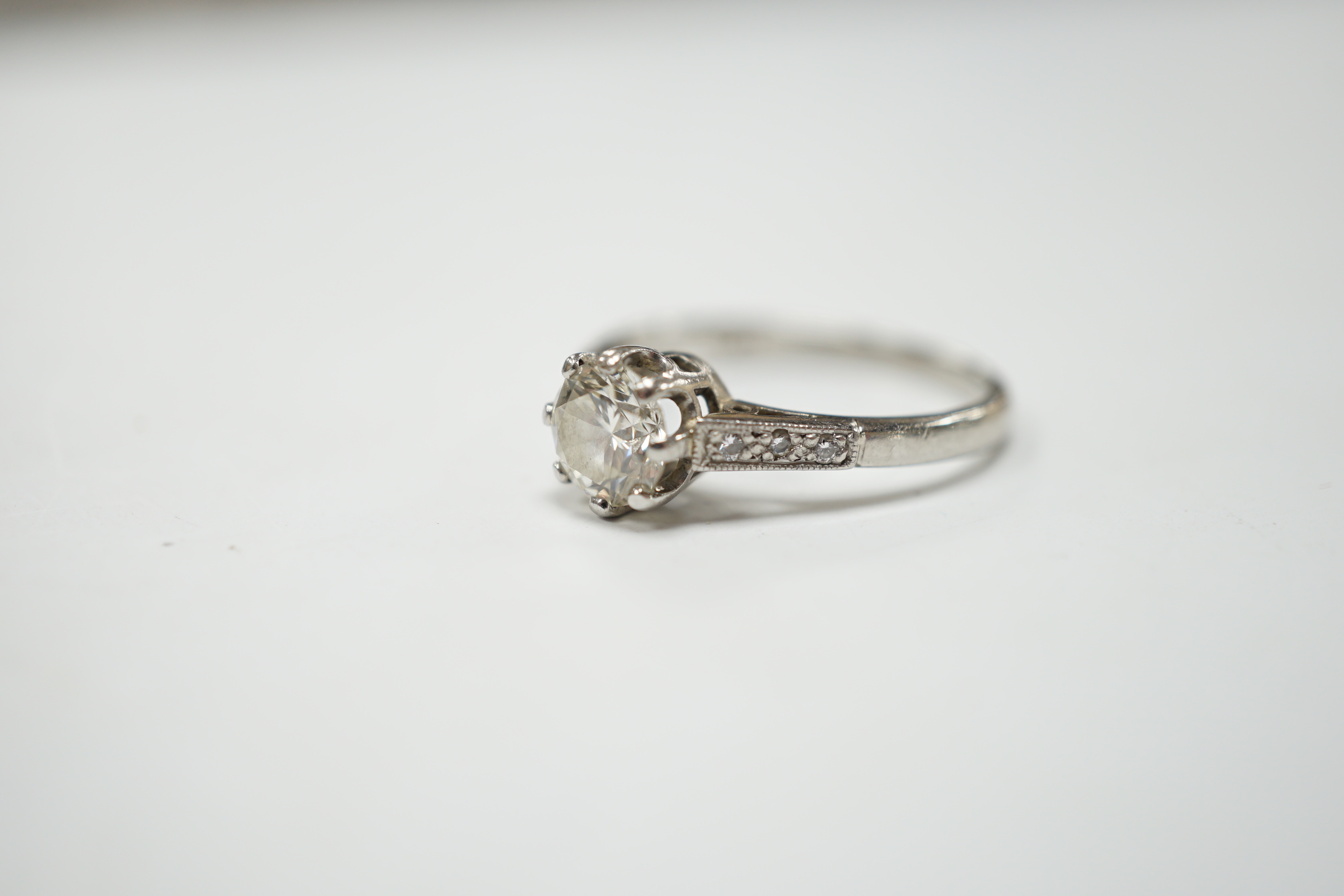 A platinum and single stone diamond set ring, with six stone diamond chip set shoulders, size P, gross weight 4.5 grams